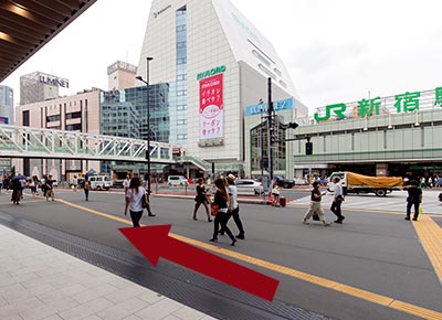 搭乘手扶電梯抵達2樓(新宿站步行者天國區)，直行後從甲州街道的出口朝西新宿方向前行。